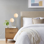 Two-light globe lamp glowing warmly on living room side table
