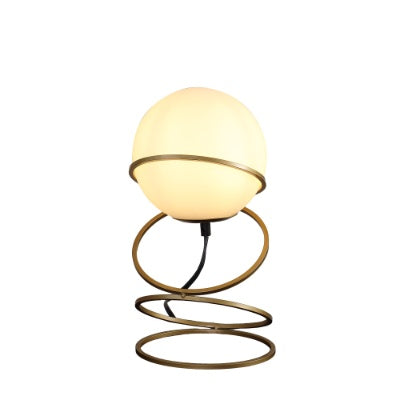 Matte gold table lamp close-up showing glass globe shade
