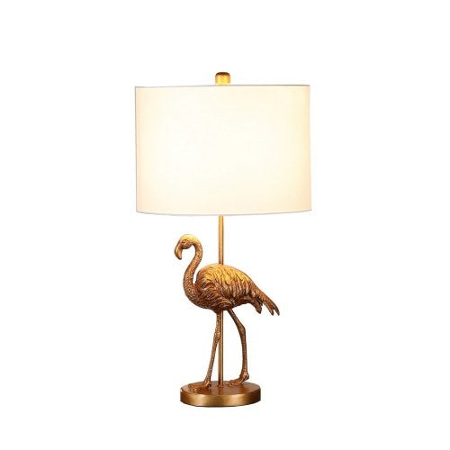 Gold flamingo decorative lamp glowing softly on bedroom nightstand