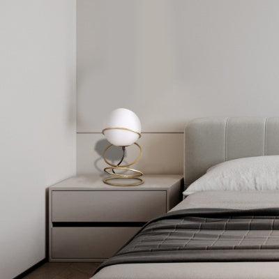 Glass globe LED bedside lamp in bedroom nightstand setting