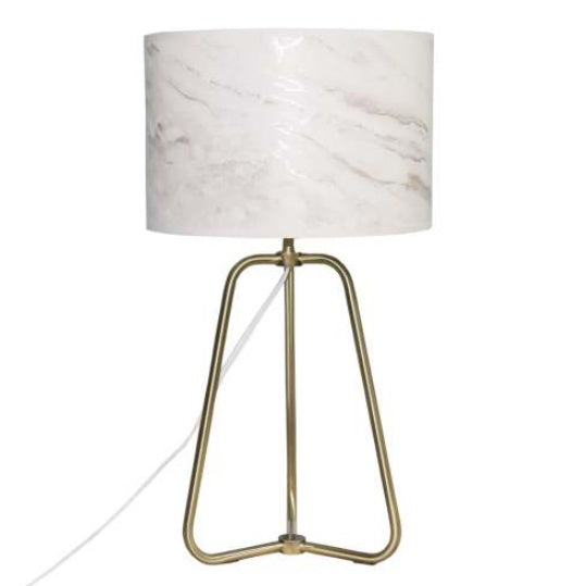 Stylish marble shade lamp glowing warmly on bedside table