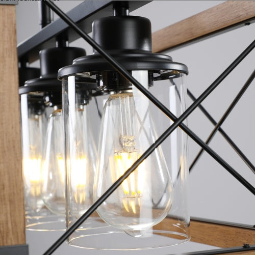 Walnut farmhouse chandelier with 5 black lampshades hanging over dining table