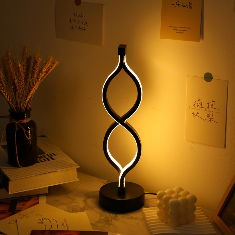 Wave shape LED table lamp set glowing in warm white on desk