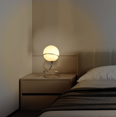Gold glass globe lamp glowing warmly on living room side table