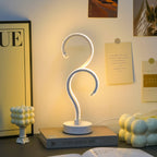 Question mark shaped LED table lamp glowing in warm white